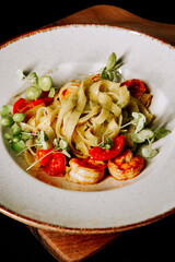 Flavorful fettuccine with shrimp, cherry tomatoes, and fresh herbs served in a rustic bowl