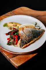 Delicious grilled fish served with fresh vegetables and lemon in a stylish presentation