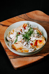 Delicious homemade pasta served on a wooden board with creamy sauce and herbs