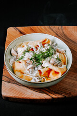 Delicious creamy pasta with mushrooms and herbs served in a rustic wooden bowl