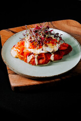 Delicious brunch dish with eggs and fresh toppings served on a wooden platter
