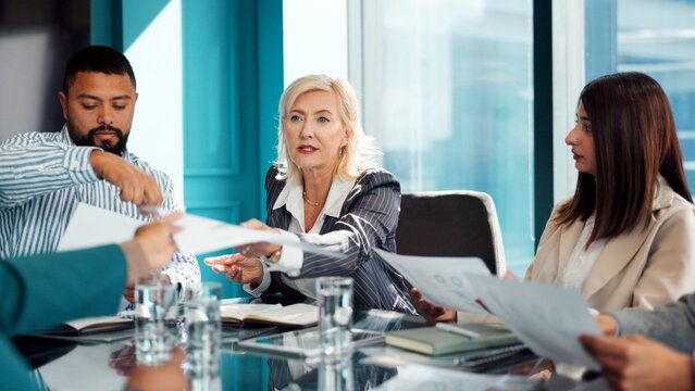 Graphs, paper or people in office with meeting, discussion or review of investment proposal. Teamwork, document or business analyst in agency with data, brainstorming or feedback on funding pitch. - Powered by Adobe