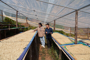 People inspect the roasting of coffee beans in large metal vats, which are a blend of Arabica and Robusta coffee beans to produce high-quality coffee with excellent taste.