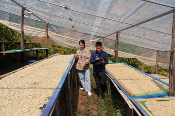 People inspect the roasting of coffee beans in large metal vats, which are a blend of Arabica and Robusta coffee beans to produce high-quality coffee with excellent taste.