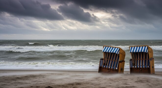 Two lonely beach chairs stand against a backdrop of stormy seascapes and turbulent clouds