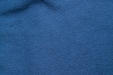 Close-up of a soft, textured blue fleece fabric background