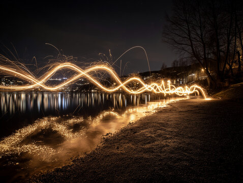 Golden light trails create mesmerizing wave patterns over a dark reflective water surface