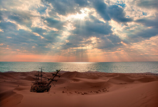 View of old ship shipwreck on the Sahara Desert at sunset - Notrh Africa, Morocco - Powered by Adobe
