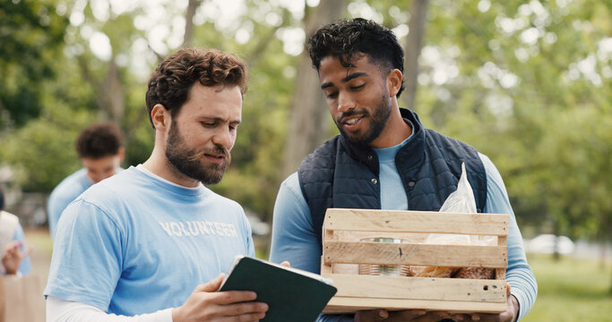 Volunteer, tablet or men in park with crate, group or package checklist in eco friendly project. Teamwork, coordination or NGO outdoor with tech, inventory track or guidance in charity donation.