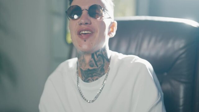 Self-confidence and self-expression by music, male rap artist singing song. Portrait of handsome cool guy with tattoos on face and body, filming musical video of hip-hop singer, be yourself and unique