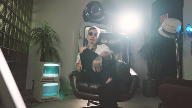 Self-confident hip-hop singer singing in studio, recording new music video. Self-expression and unique style of young man, talented rap artist performing new song, art hobby of modern young people