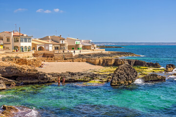 View at beach houses at the mediterranean sea and women bathing in the water