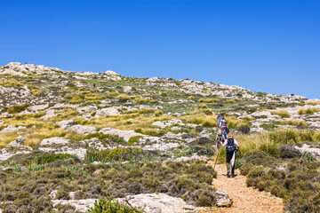 Hikers on the way up at a mountain trail in a rocky landscape at a mountain