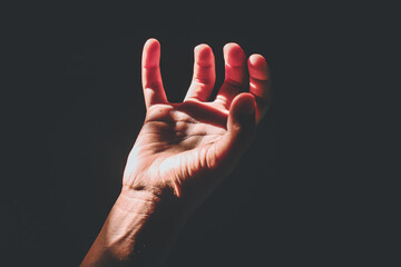 man's hand with light in the dark