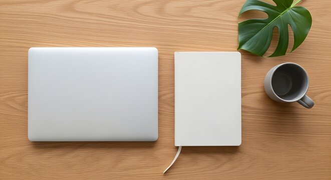 Silver laptop white notebook gray mug and green leaf on wood image - Powered by Adobe