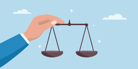Hand holding scales of justice in the sky concept of fairness