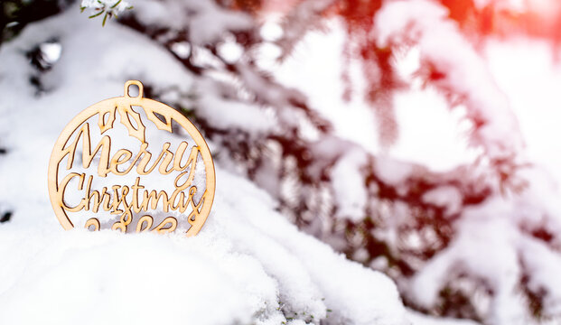 Congratulations on Christmas on the snow-covered branches of a fir tree
