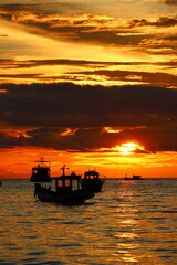 Sunset boat floating over the peaceful tropical sea