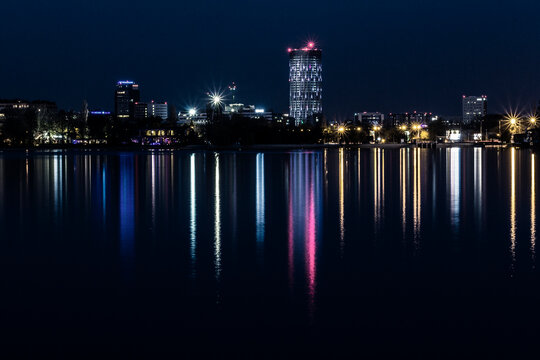 chicago skyline at night hows a cityscape at night with reflections on water. Full-frame composition, blue-purple tone. Realistic style, urban background