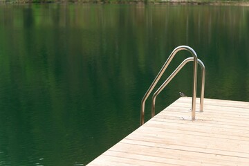 Lake platform with ladder and forest background