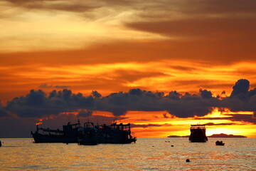 Obraz premium Sunset boat floating over the peaceful tropical sea