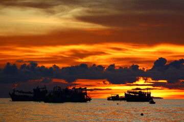 Sunset boat floating over the peaceful tropical sea