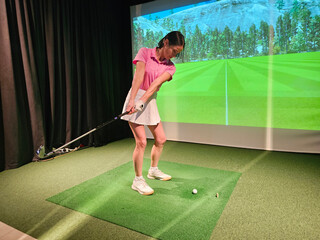 Golf practice session indoors with a player using a swing simulation in a realistic