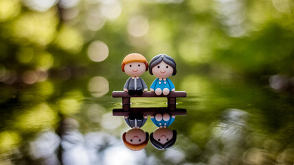 Cute Miniature Couple Art: Boy and Girl Sitting by Forest Water Reflection
