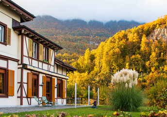 Beautiful wooden house with autumn foliage garden