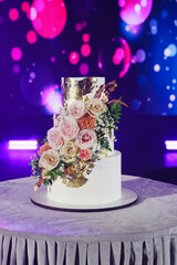 Elegant wedding cake adorned with flowers and gold accents