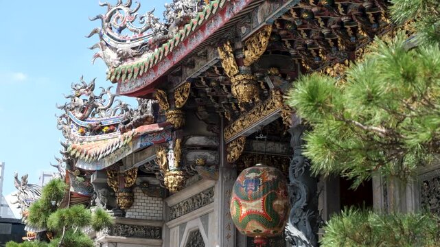 The ornate roofline and carved architectural details of the historic Longshan Temple in Taipei, Taiwan, featuring intricate, decorative beams, and colorful traditional craftsmanship