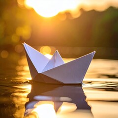 Paper boat floating on water at sunset