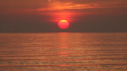 Vibrant Sunset Over Calm Ocean with Fiery Reflection