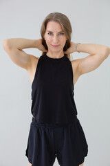 Confident Woman in Black Athletic Wear Posing in Studio