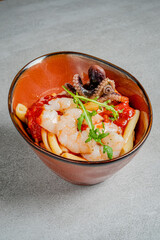 A vibrant seafood pasta dish showcases fresh shrimp and octopus in a rich red sauce