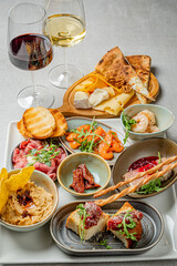 A colorful array of appetizers and wine glasses invites enjoyment at the table