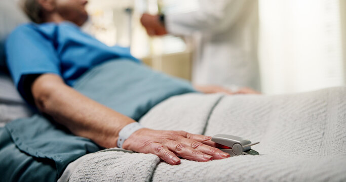 Hands, senior person and oximeter in hospital bed to monitor pulse, blood levels and surgery recovery. Closeup, elderly patient and medical device to track oxygen, chronic condition and critical care