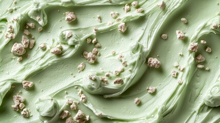 Mint-green cream swirls topped with scattered chunks, close-up texture