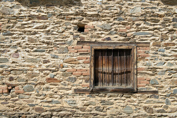 The harmony of wooden windows and stone walls. Stone-walled structures with wooden shutters....