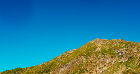 Parachutist in the distance over the mountain peak.