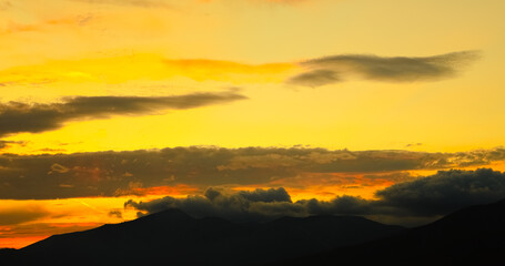 Dramatic sunset sky with yellow clouds.