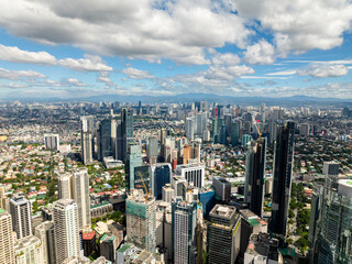 Business office buildings and high rise towers in Makati. Blue sky and clouds. Metro Manila, Philippines.