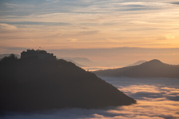 Sonnenuntergang über dem Nebelmeer vom Beurener Fels zur Burg Hohenneuffen, Schwäbische Alb, Baden-Württemberg, Deutschland.