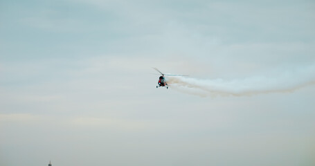 Fototapeta premium HeliForce MI-2 helicopter makes a cloud of smoke in an air show. Bucharest Air Show BIAS 2024.