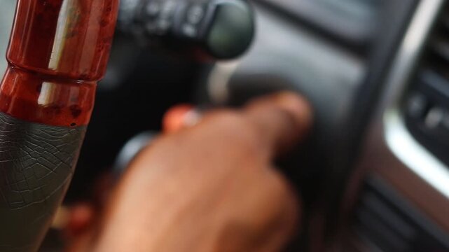 Close up of hand turning the key in the ignition of a car