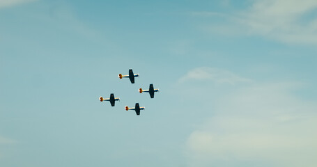 Four Yak-52 aircraft that synchronize perfectly and fly at an air show. Yak-52 aircraft perform a demonstration flight at BIAS 2024. YAK-52 Air Force Romania