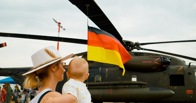 Women holding their child and showing the child the helicopter Sikorsky CH-53GS. Bucharest Air Show, BIAS 2024.