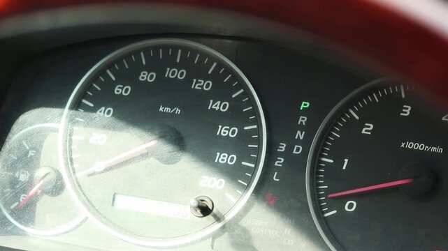Closer up of a car dashboard with instruments like a speedometer, tachometer and burning lights. The engine revs and the pointer of the tachometer goes up. Mechanic testing the car after fixing engine