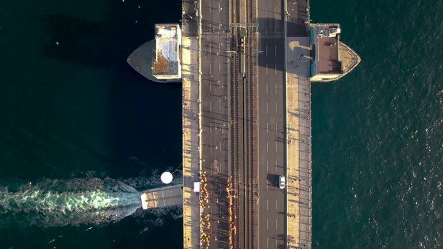 Top-view drone shot tracking Istanbul Marathon runners across Galata Bridge. Ideal for sports coverage, aerial documentaries, marathon promos, and dynamic city footage. - Powered by Adobe