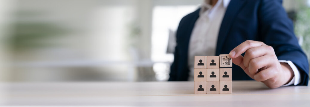 Training and Learning Development. Wooden blocks with human icons, placing a certification block on top, symbolizing structured training, skills development and organized learning pathways.